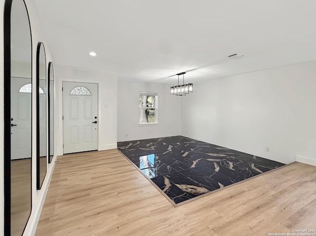 interior space featuring light hardwood / wood-style floors and a chandelier