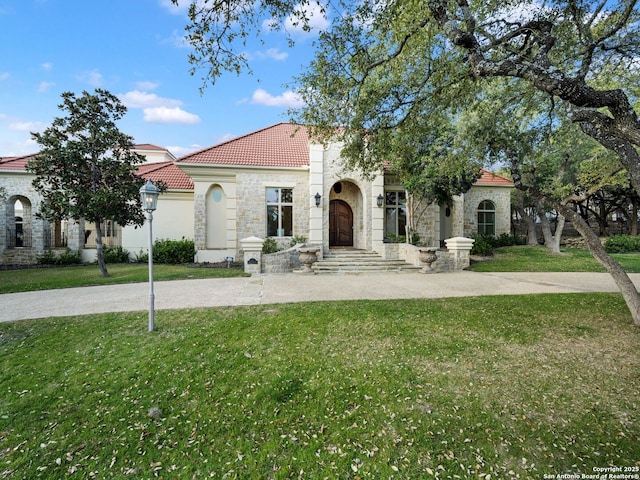 mediterranean / spanish-style house featuring a front lawn