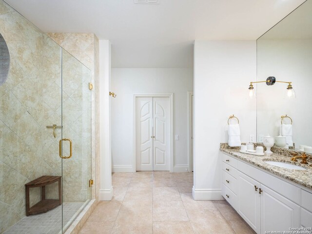 bathroom featuring vanity, a shower with shower door, and tile patterned flooring