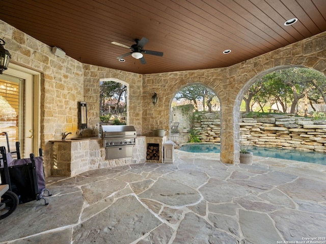 view of patio with ceiling fan, area for grilling, and a grill