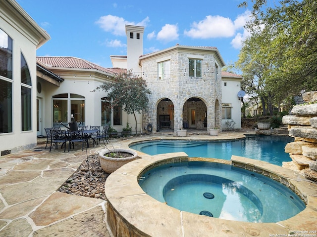view of swimming pool featuring a patio and an in ground hot tub