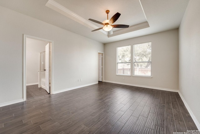 empty room with dark wood-type flooring, ceiling fan, and a tray ceiling