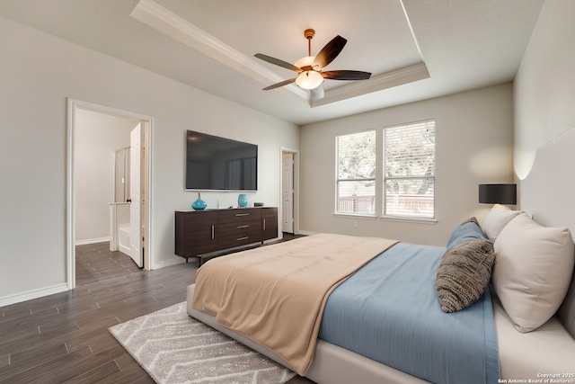 bedroom featuring dark hardwood / wood-style flooring, ornamental molding, ceiling fan, a raised ceiling, and ensuite bath