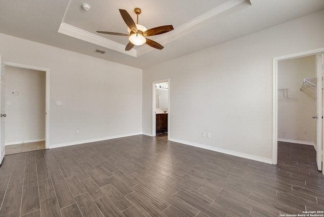 empty room featuring a raised ceiling and ceiling fan