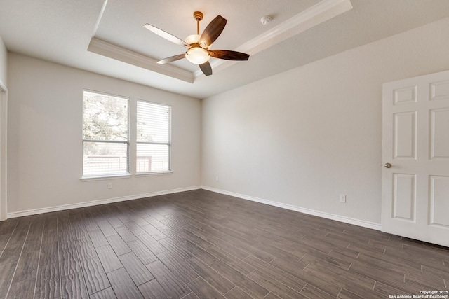 unfurnished room with dark wood-type flooring, a raised ceiling, and ceiling fan