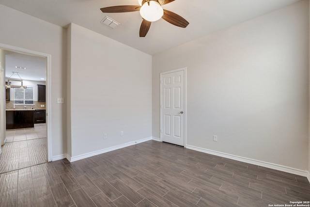 unfurnished room featuring ceiling fan and dark hardwood / wood-style floors