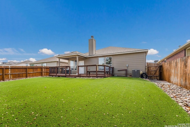 rear view of house featuring cooling unit, a yard, and a deck