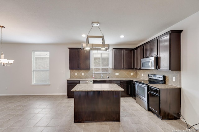 kitchen with pendant lighting, appliances with stainless steel finishes, dark brown cabinetry, a kitchen island, and decorative backsplash