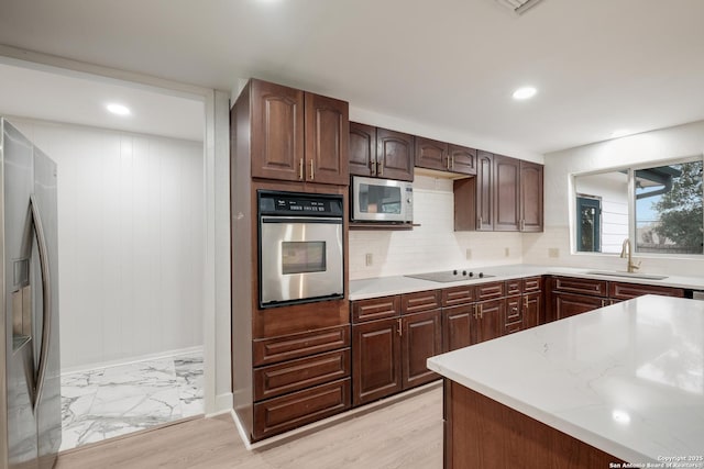 kitchen featuring dark brown cabinets, appliances with stainless steel finishes, sink, and decorative backsplash