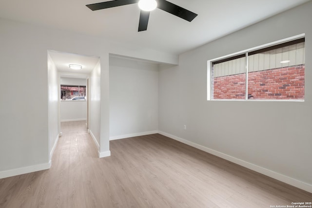 empty room with ceiling fan and light hardwood / wood-style floors