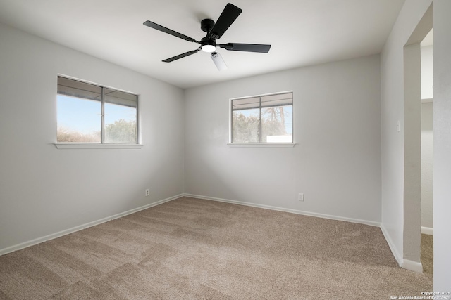 unfurnished room with plenty of natural light, light colored carpet, and ceiling fan