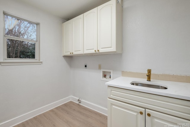 laundry area with sink, cabinets, light hardwood / wood-style floors, hookup for a washing machine, and hookup for an electric dryer