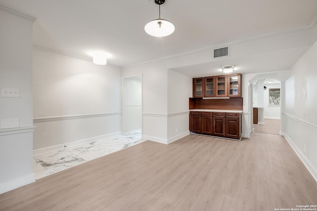 empty room featuring crown molding and light hardwood / wood-style floors