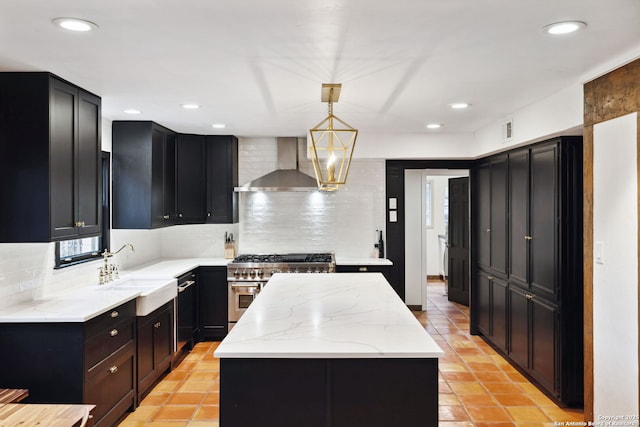 kitchen featuring a kitchen island, decorative light fixtures, sink, high end stainless steel range oven, and wall chimney exhaust hood