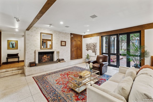 living room with a premium fireplace and french doors