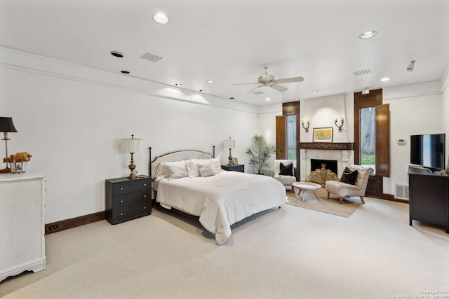 bedroom featuring light carpet, crown molding, and a fireplace