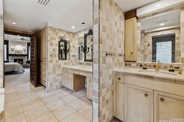 bathroom with tasteful backsplash, tile walls, tile patterned flooring, vanity, and ceiling fan