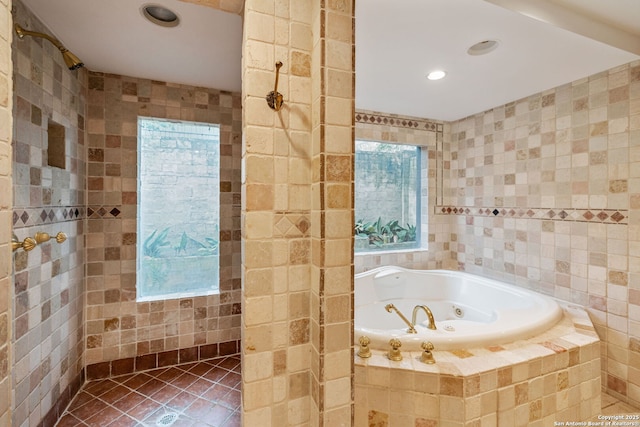 bathroom featuring tile patterned flooring, tiled bath, and tile walls