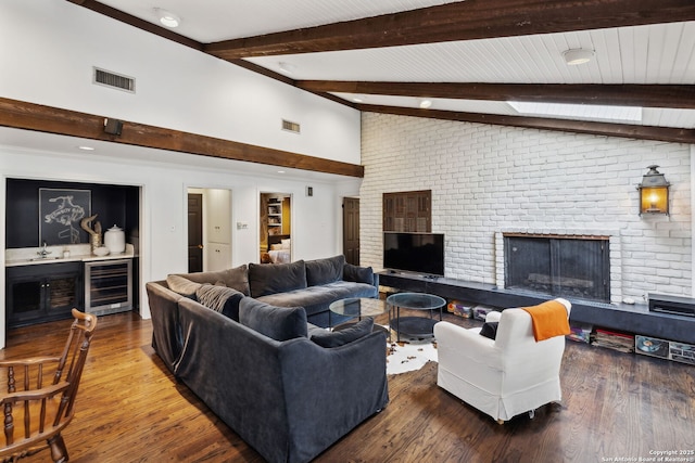 living room featuring wine cooler, hardwood / wood-style flooring, a fireplace, and lofted ceiling with beams