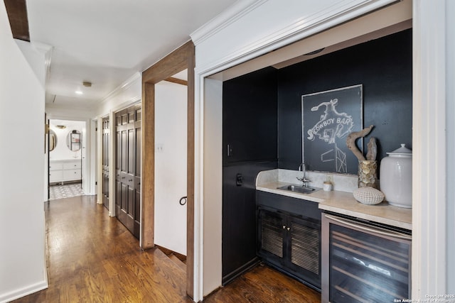 bar with sink, dark wood-type flooring, and beverage cooler