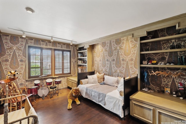 bedroom featuring ornamental molding, dark hardwood / wood-style floors, and track lighting