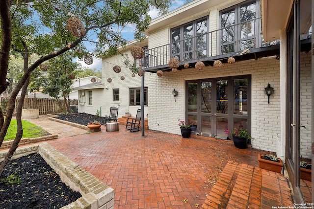 exterior space with a patio, a balcony, and french doors