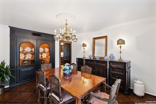 dining space with ornamental molding and a notable chandelier