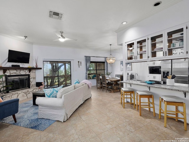 1048 Parkview Dr, Canyon Lake, TX 78133 - living room with crown molding, ceiling fan, a fireplace, and sink