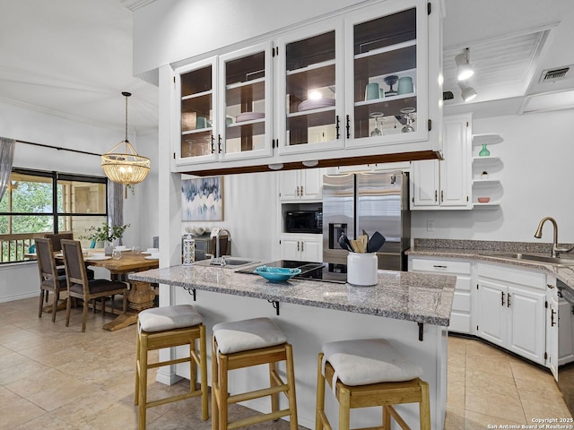1048 Parkview Dr, Canyon Lake, TX 78133 - kitchen with a breakfast bar, decorative light fixtures, white cabinetry, sink, and stainless steel fridge with ice dispenser