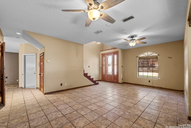 tiled spare room featuring ceiling fan and a textured ceiling