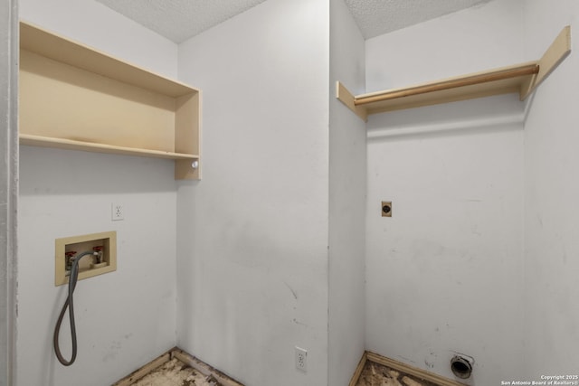 clothes washing area with hookup for a washing machine, hookup for an electric dryer, and a textured ceiling