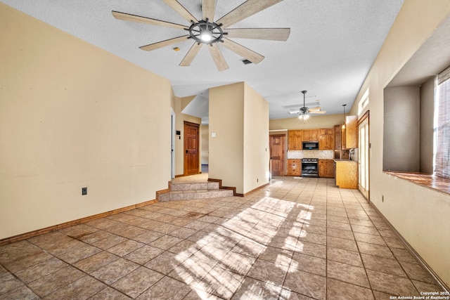 unfurnished living room featuring ceiling fan and a textured ceiling