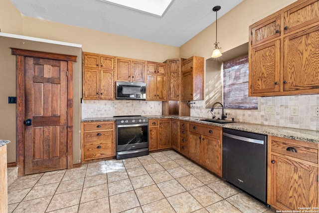 kitchen featuring stainless steel electric stove, dishwasher, sink, hanging light fixtures, and light stone countertops