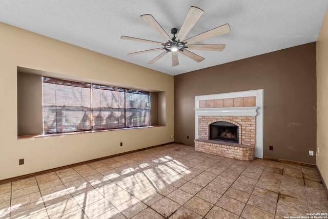 unfurnished living room with ceiling fan, a brick fireplace, and a textured ceiling