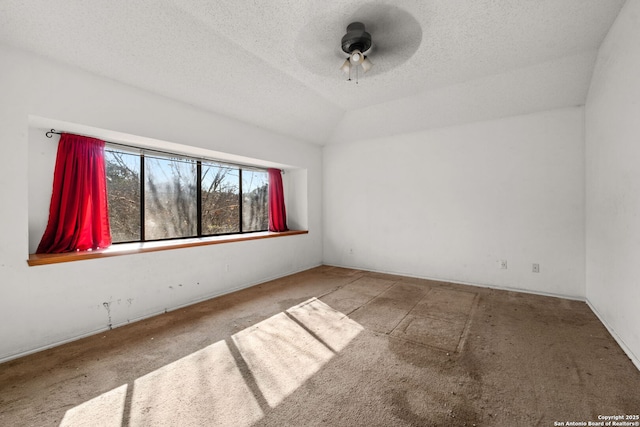 unfurnished room with ceiling fan, vaulted ceiling, and a textured ceiling