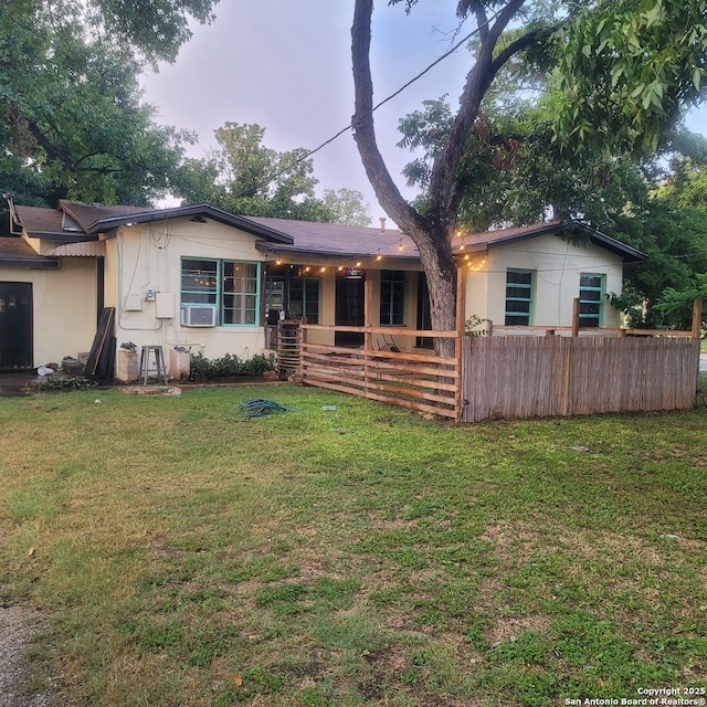 view of front of property with cooling unit and a front lawn