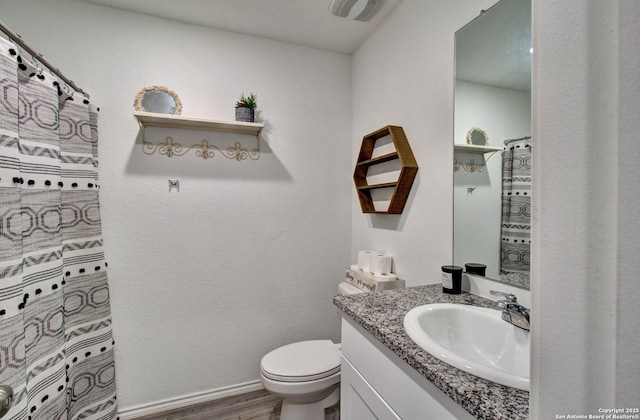 bathroom with wood-type flooring, toilet, and vanity