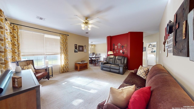 living room with ceiling fan, washer / dryer, and light carpet