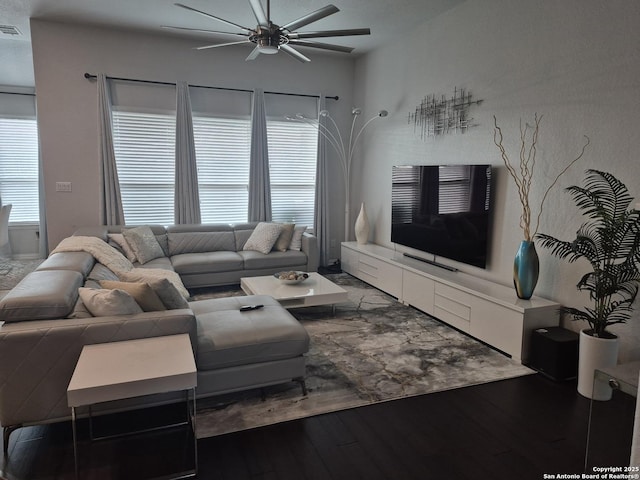 living area with visible vents, ceiling fan, and wood finished floors