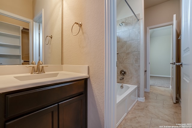 bathroom with bathtub / shower combination, vanity, and baseboards