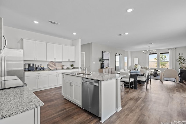 kitchen with sink, stainless steel appliances, white cabinets, and a center island with sink