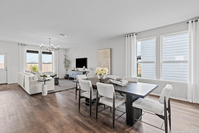 dining room featuring dark hardwood / wood-style floors and an inviting chandelier