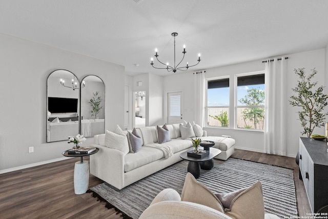 living room featuring an inviting chandelier and dark hardwood / wood-style floors