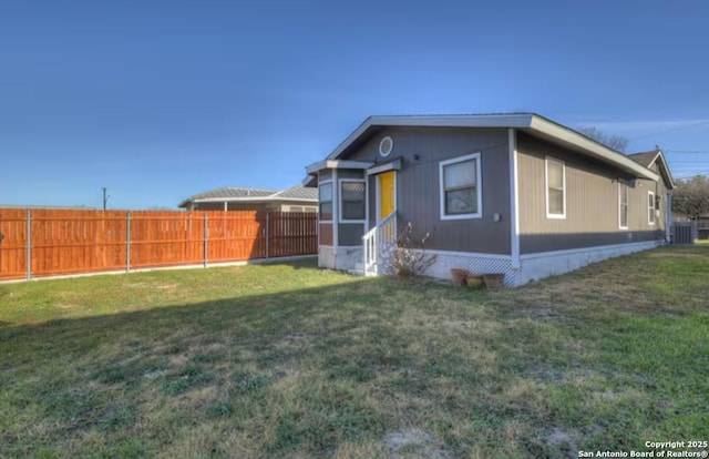 view of front of house featuring central AC and a front lawn