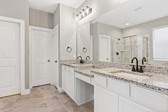 bathroom with vanity and a shower with door