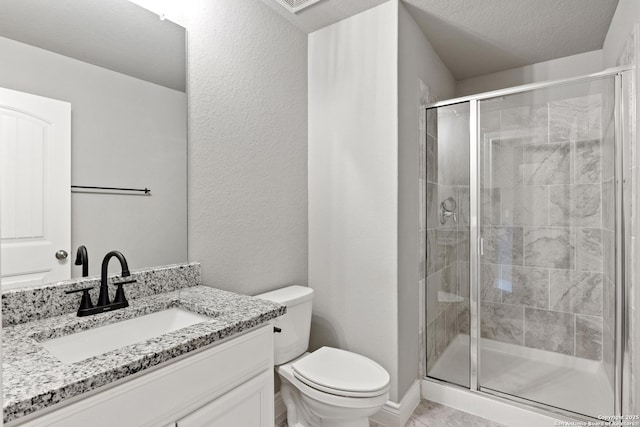 bathroom with toilet, vanity, a textured ceiling, and walk in shower