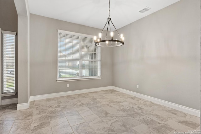 unfurnished room featuring a notable chandelier