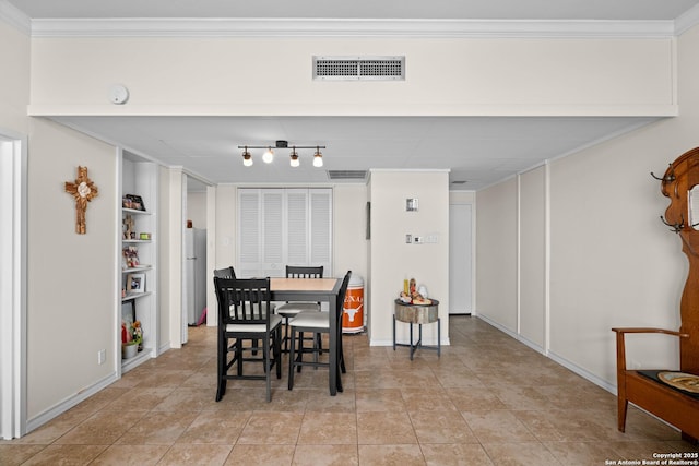 dining room featuring crown molding, light tile patterned floors, and built in shelves