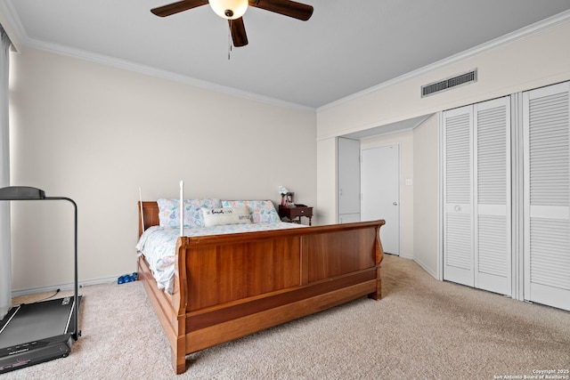 carpeted bedroom with crown molding, ceiling fan, and a closet