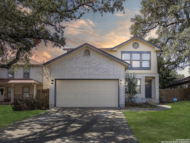 view of front of home with a garage and a lawn